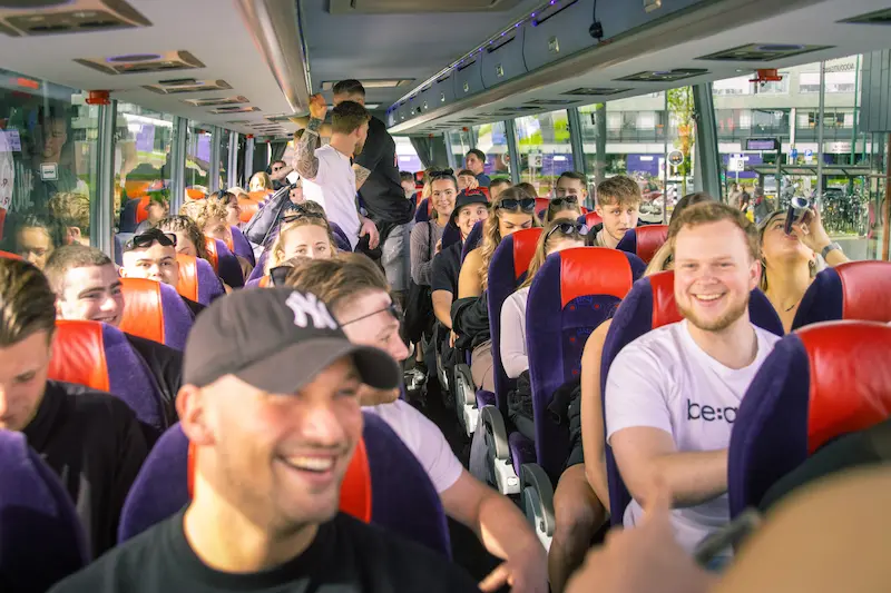 Festivalgangers in een touringcar van eleven travel