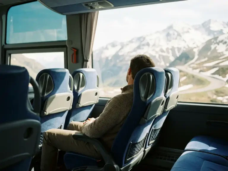 Passagier ontspant in luxe touringcar terwijl hij uitkijkt over berglandschap door panoramisch raam